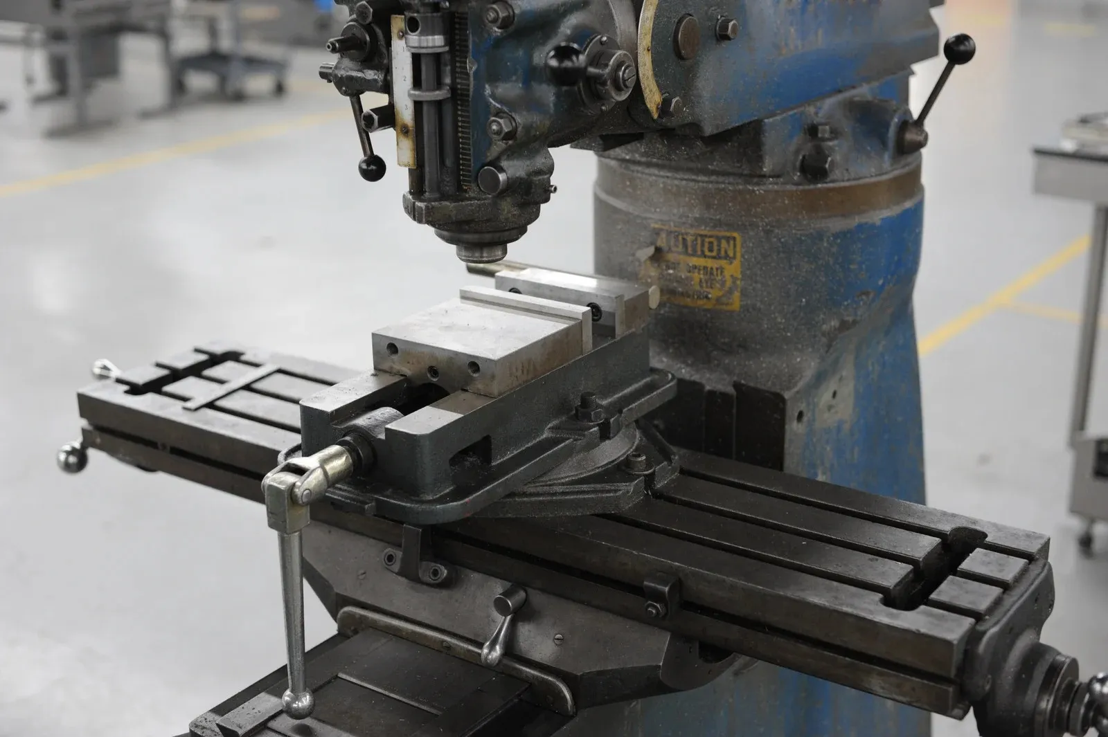 Floor-standing drill press with vise holding a metal block