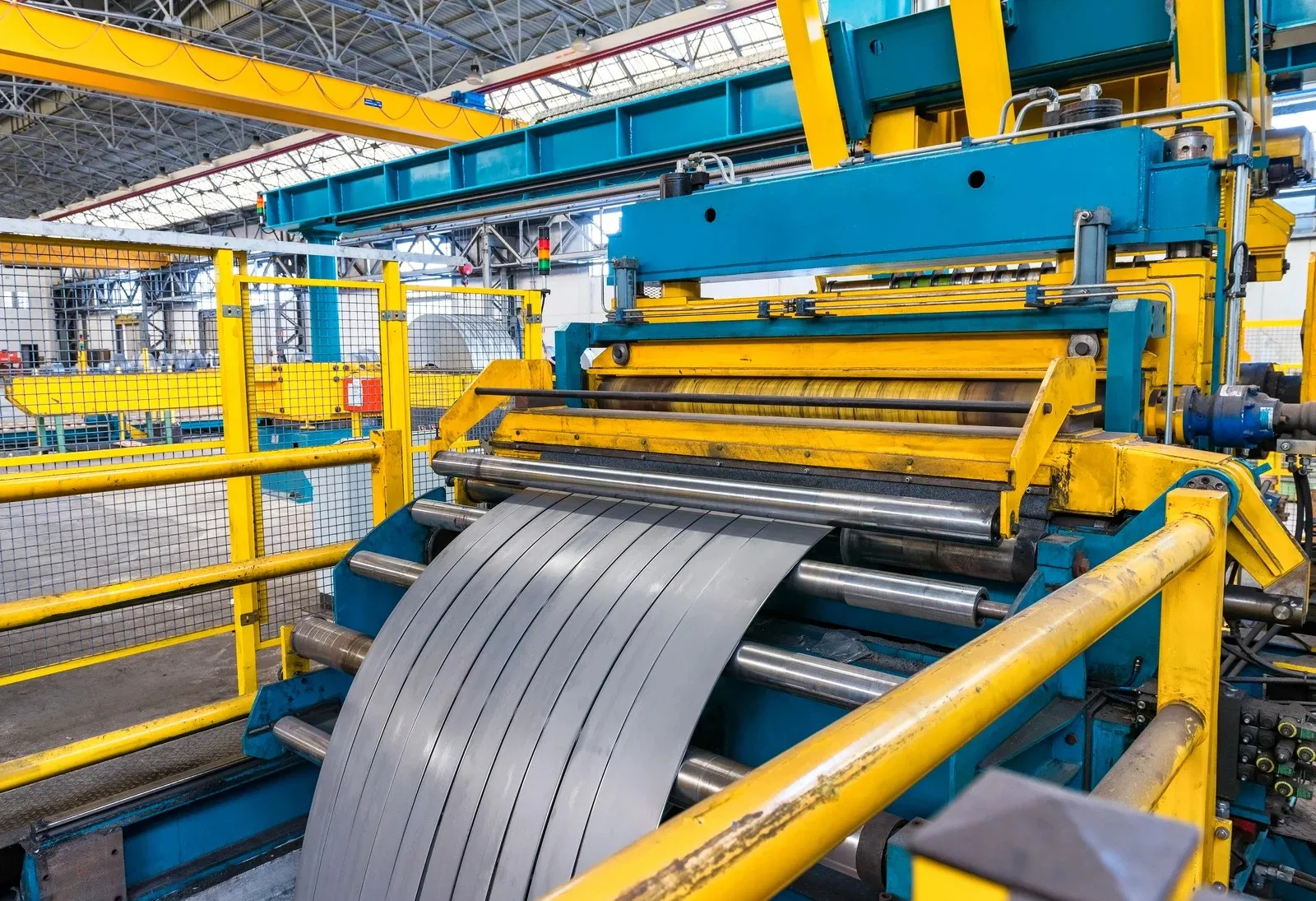 Steel coil feeding through an industrial slitting and rolling line
