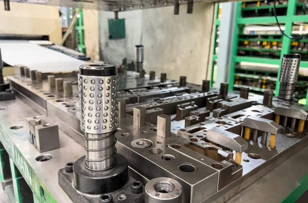 Stamping die with ball-cage guide posts and tooling on a press bed