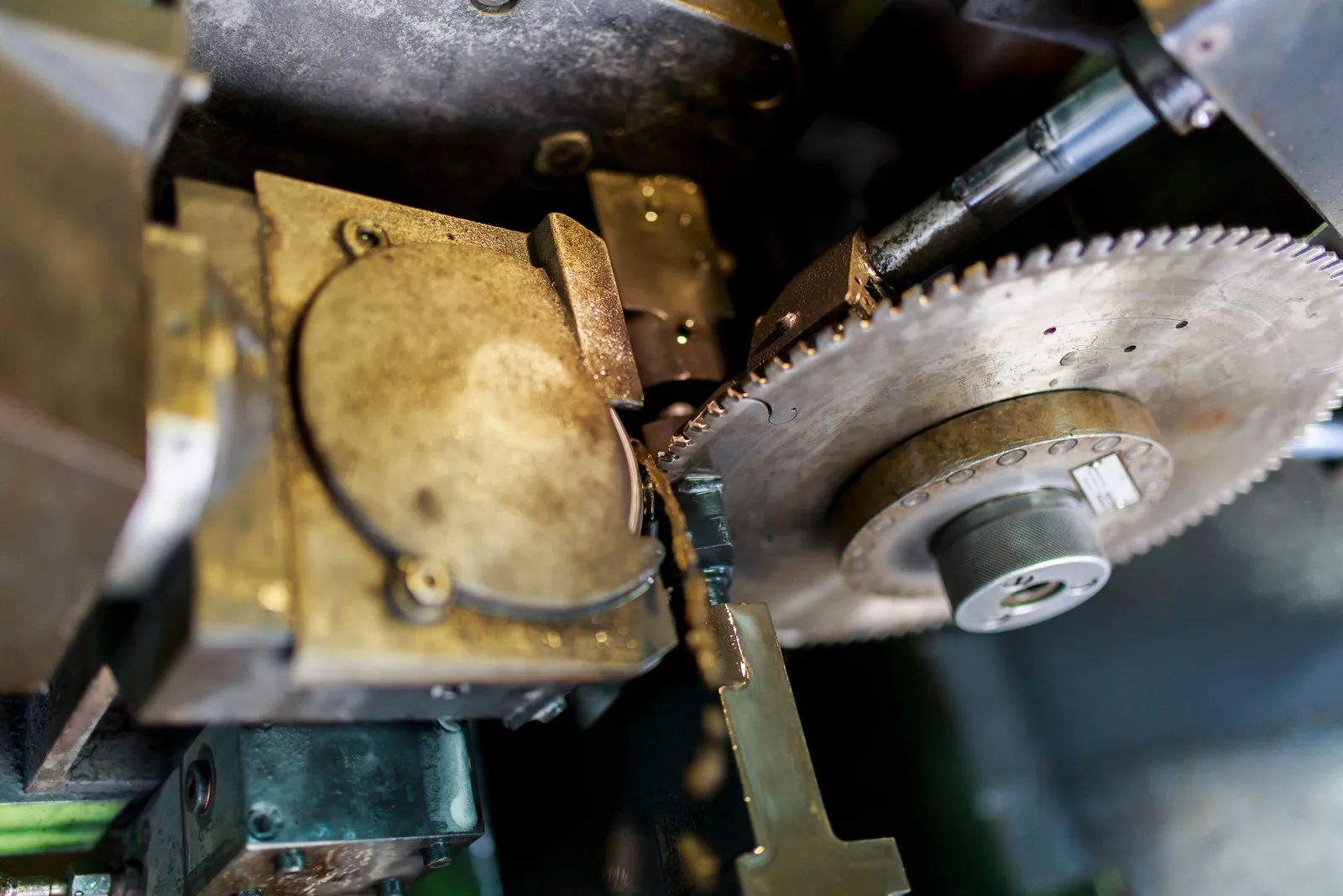 Circular saw blade cutting through a clamped metal workpiece